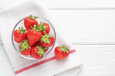 Photo of Fresh ripe strawberries in bowl on white wooden table, top view. Space for text