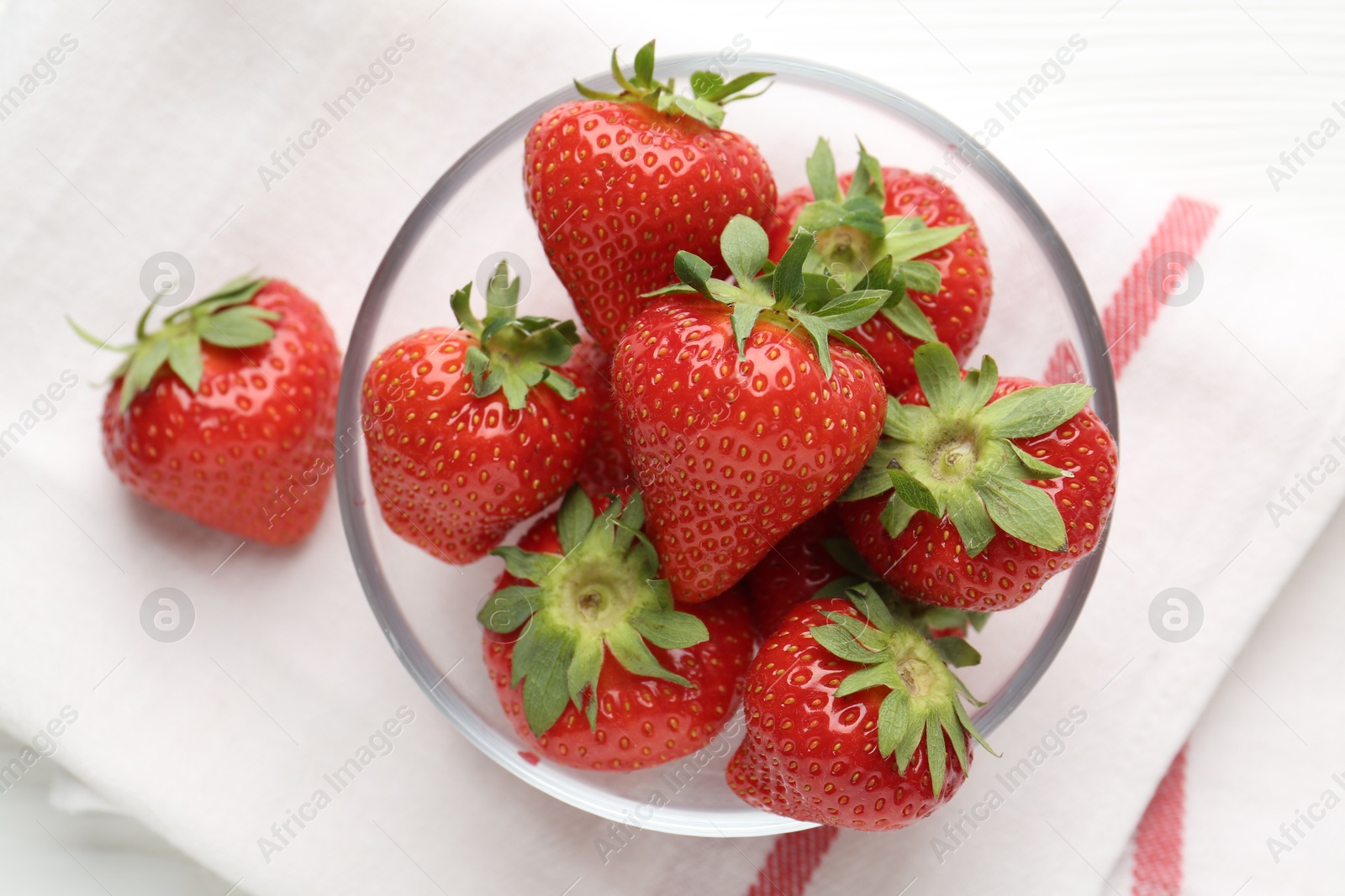 Fresh ripe strawberries in bowl on white table, top view Photo of Fresh ripe strawberries in bowl on white table, top view