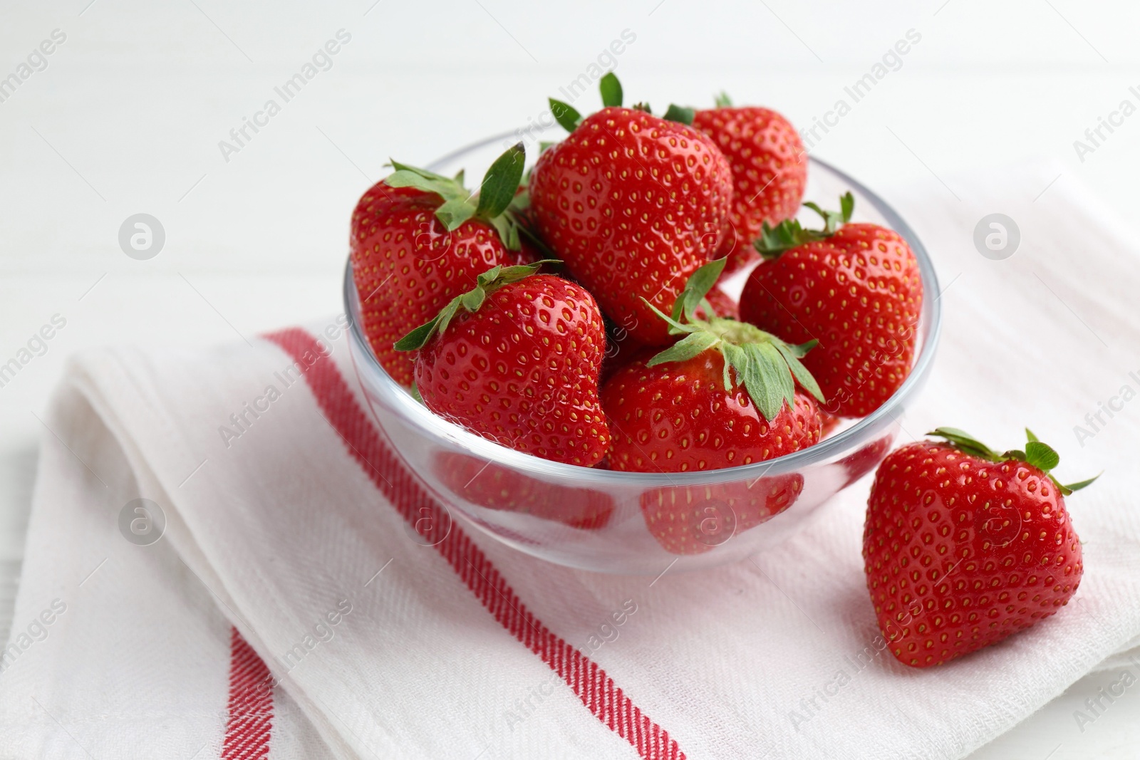 Fresh ripe strawberries in bowl on white wooden table, closeup Photo of Fresh ripe strawberries in bowl on white wooden table, closeup