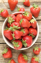 Photo of Fresh ripe strawberries in bowl on wooden table, flat lay