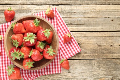 Photo of Fresh ripe strawberries in bowl on wooden table, flat lay. Space for text