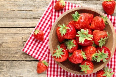Photo of Fresh ripe strawberries in bowl on wooden table, flat lay. Space for text