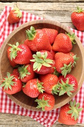 Photo of Fresh ripe strawberries in bowl on wooden table, flat lay