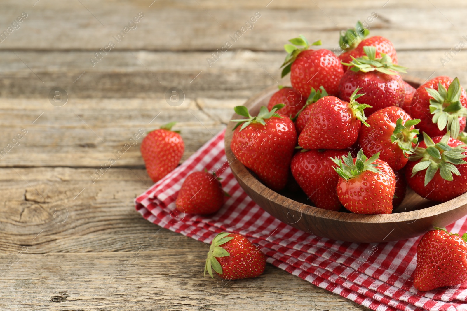 Fresh ripe strawberries in bowl on wooden table, closeup. Space for text Photo of Fresh ripe strawberries in bowl on wooden table, closeup. Space for text