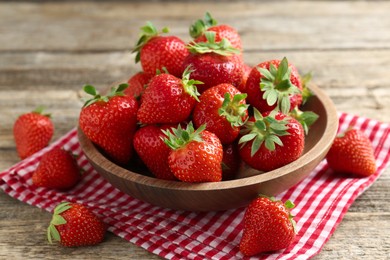 Photo of Fresh ripe strawberries in bowl on wooden table, closeup