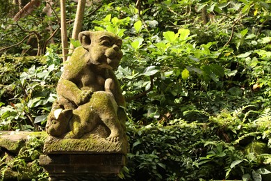 Photo of Bali, Indonesia - June 2, 2025: Beautiful ancient monkey statue and lush greenery outdoors