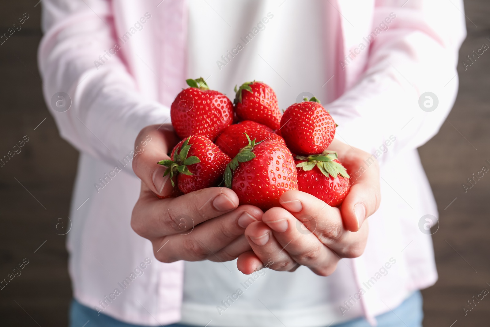 Woman with delicious ripe strawberries indoors, closeup Photo of Woman with delicious ripe strawberries indoors, closeup