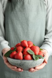 Photo of Woman with bowl of delicious ripe strawberries, closeup