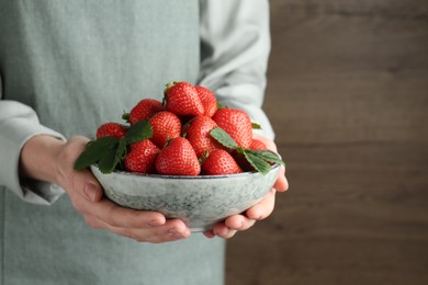 Photo of Woman with delicious ripe strawberries indoors, closeup. Space for text