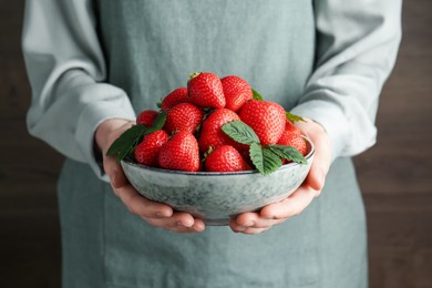 Photo of Woman with delicious ripe strawberries indoors, closeup