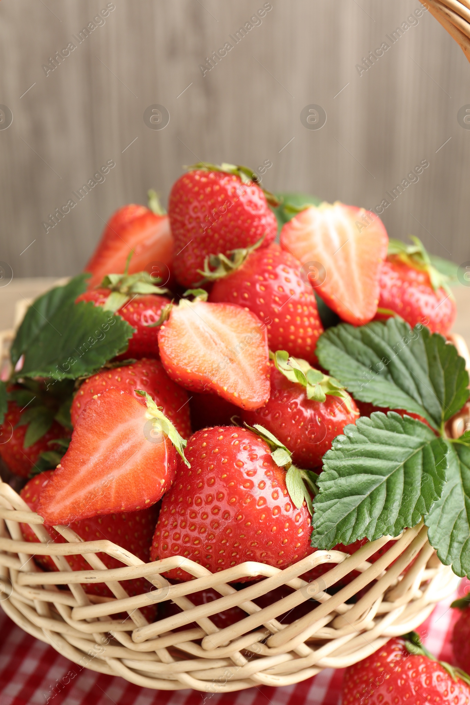 Delicious ripe strawberries in wicker basket on table, closeup Photo of Delicious ripe strawberries in wicker basket on table, closeup