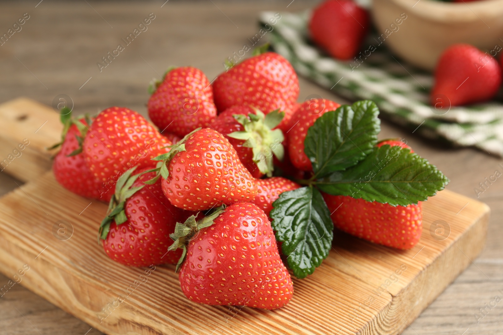 Delicious ripe strawberries and green leaves on table, closeup Photo of Delicious ripe strawberries and green leaves on table, closeup