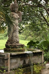 Photo of Bali, Indonesia - June 2, 2025: Beautiful ancient goddess statue and tropical trees in Ubud Monkey Forest