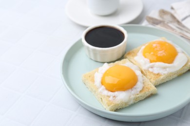 Photo of Tasty kaya toasts with half-boiled eggs served on white tiled table, closeup. Traditional asian breakfast