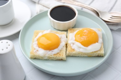 Photo of Tasty kaya toasts with half-boiled eggs served on white tiled table, closeup. Traditional asian breakfast