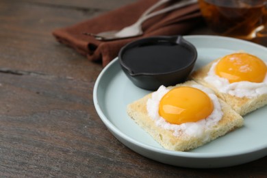 Photo of Traditional asian breakfast with tasty kaya toasts and half-boiled eggs served on wooden table, closeup. Space for text