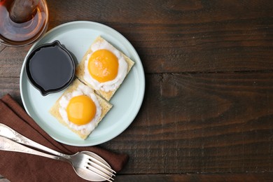 Photo of Traditional asian breakfast with tasty kaya toasts and half-boiled eggs served on wooden table, flat lay. Space for text