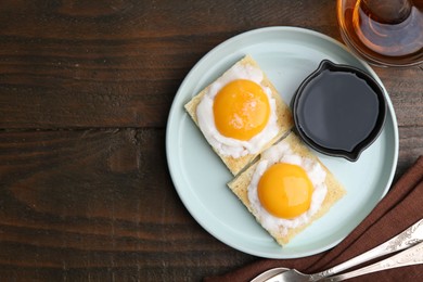 Photo of Traditional asian breakfast with tasty kaya toasts and half-boiled eggs served on wooden table, flat lay. Space for text