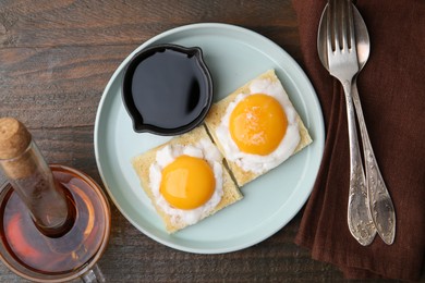 Photo of Tasty kaya toasts with half-boiled eggs served on wooden table, flat lay. Traditional asian breakfast