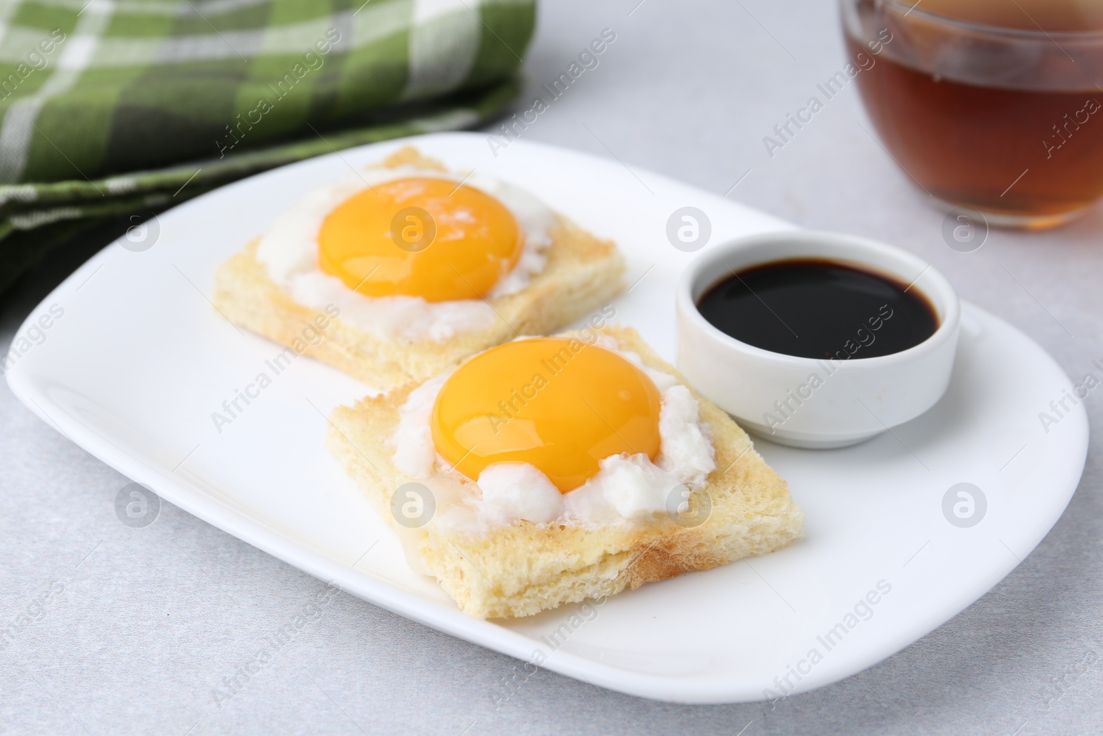 Tasty kaya toasts with half-boiled eggs served on light grey table, closeup. Traditional asian breakfast Photo of Tasty kaya toasts with half-boiled eggs served on light grey table, closeup. Traditional asian breakfast