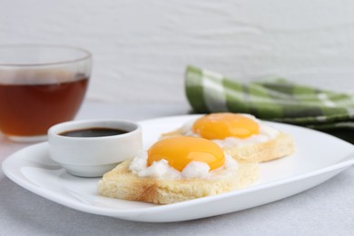 Photo of Tasty kaya toasts with half-boiled eggs served on light grey table, closeup. Traditional asian breakfast