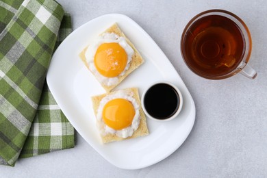 Photo of Traditional asian breakfast with tasty kaya toasts and half-boiled eggs served on light grey table, flat lay