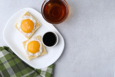 Photo of Traditional asian breakfast with tasty kaya toasts and half-boiled eggs served on light grey table, flat lay. Space for text