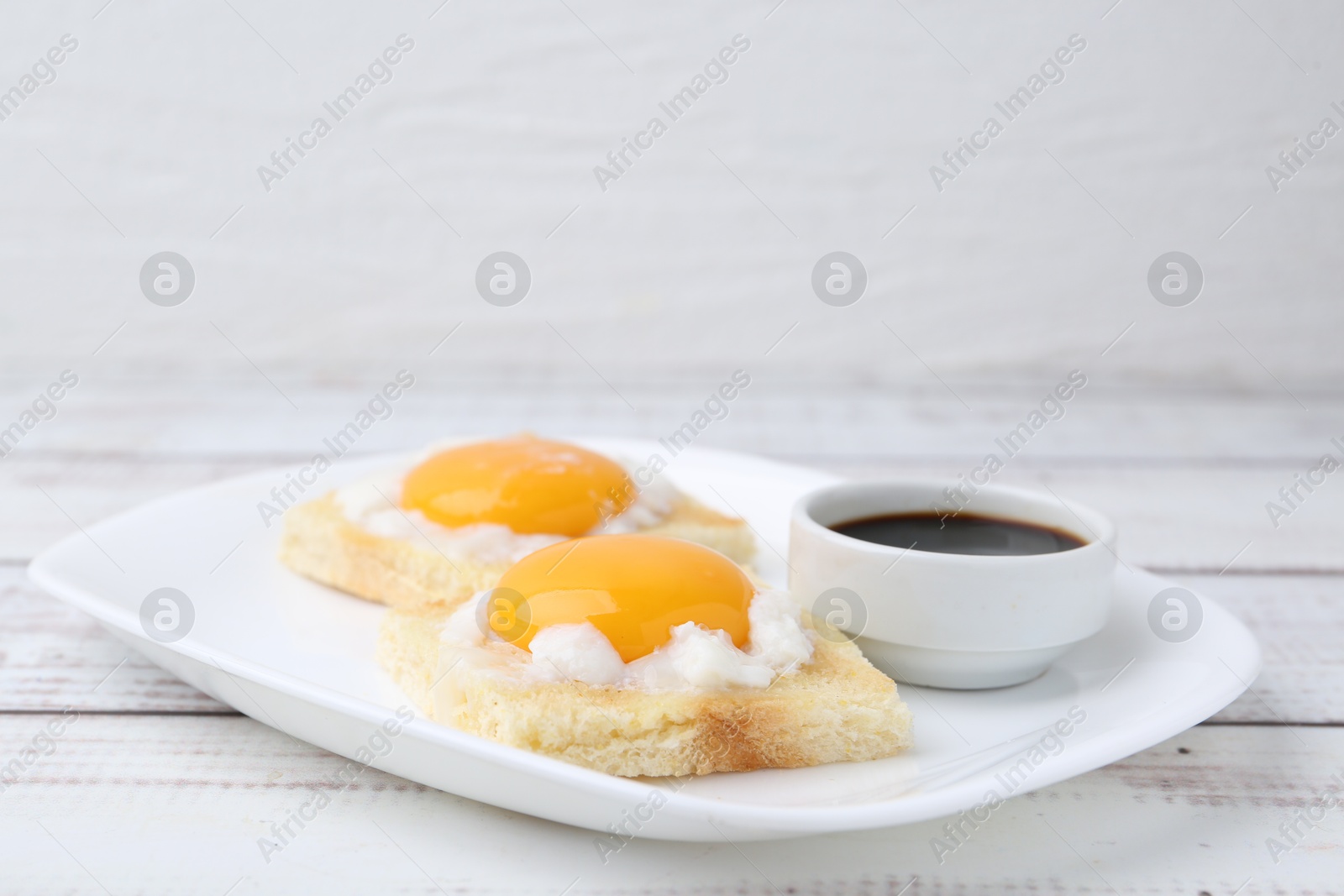 Tasty kaya toasts with half-boiled eggs served on white wooden table, closeup. Traditional asian breakfast Photo of Tasty kaya toasts with half-boiled eggs served on white wooden table, closeup. Traditional asian breakfast