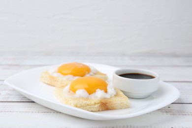 Photo of Tasty kaya toasts with half-boiled eggs served on white wooden table, closeup. Traditional asian breakfast