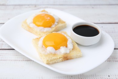 Photo of Tasty kaya toasts with half-boiled eggs served on white wooden table, closeup. Traditional asian breakfast
