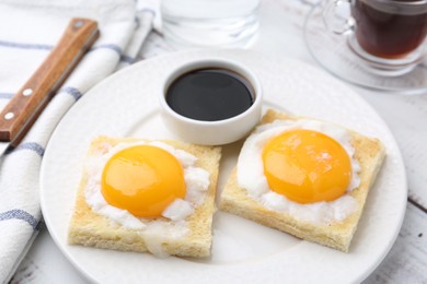 Photo of Tasty kaya toasts with half-boiled eggs served on white wooden table, closeup. Traditional asian breakfast