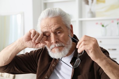 Photo of Senior man suffering from eyestrain at home