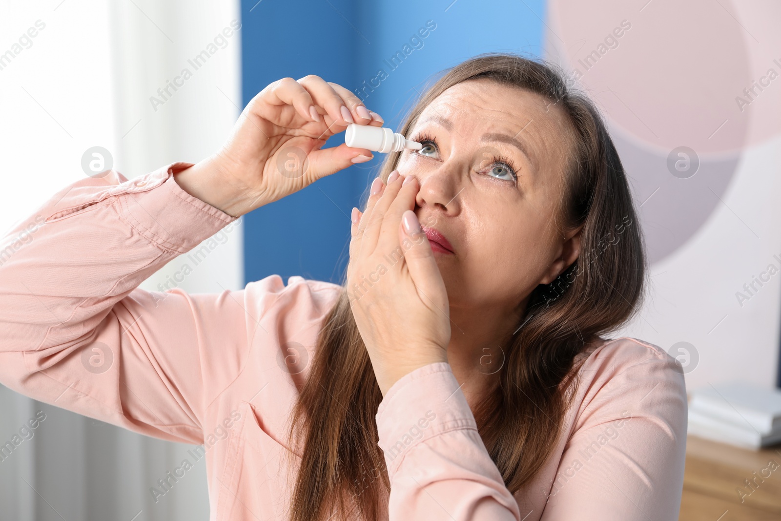 Woman with vision problem applying eye drops at home Photo of Woman with vision problem applying eye drops at home