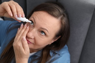 Photo of Woman applying eye drops at home, above view