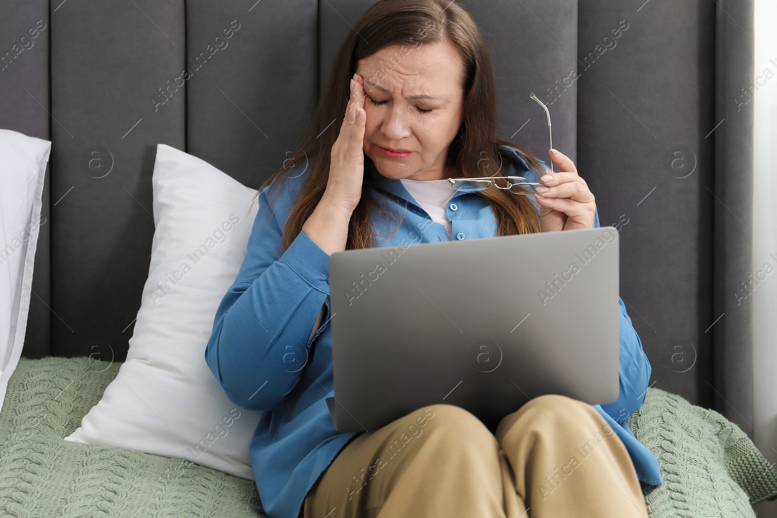 Woman with vision problem using laptop on bed at home Photo of Woman with vision problem using laptop on bed at home
