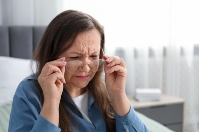 Photo of Woman with vision problem wearing glasses at home, space for text