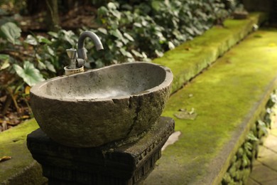 Photo of Stone washbasin in park on summer day