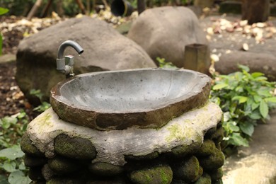 Photo of Stone washbasin in park on summer day