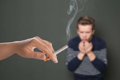 Image of Passive smoking. Boy coughing because of woman smoking nearby on grey background. Selective focus