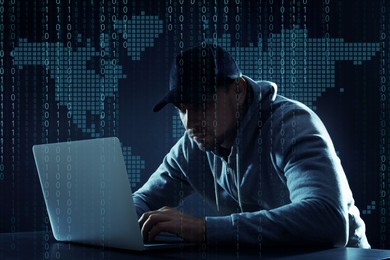 Image of Cyber attack. Hacker working on laptop at table against world map. Binary code around him