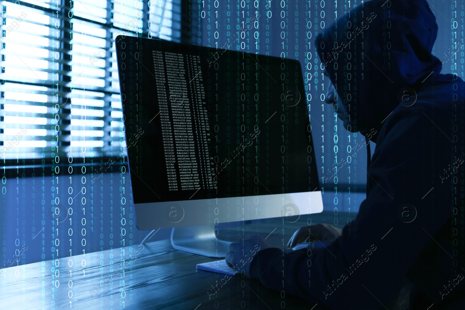Cyber attack. Hacker working on computer at table in dark room. Binary code around him Image of Cyber attack. Hacker working on computer at table in dark room. Binary code around him