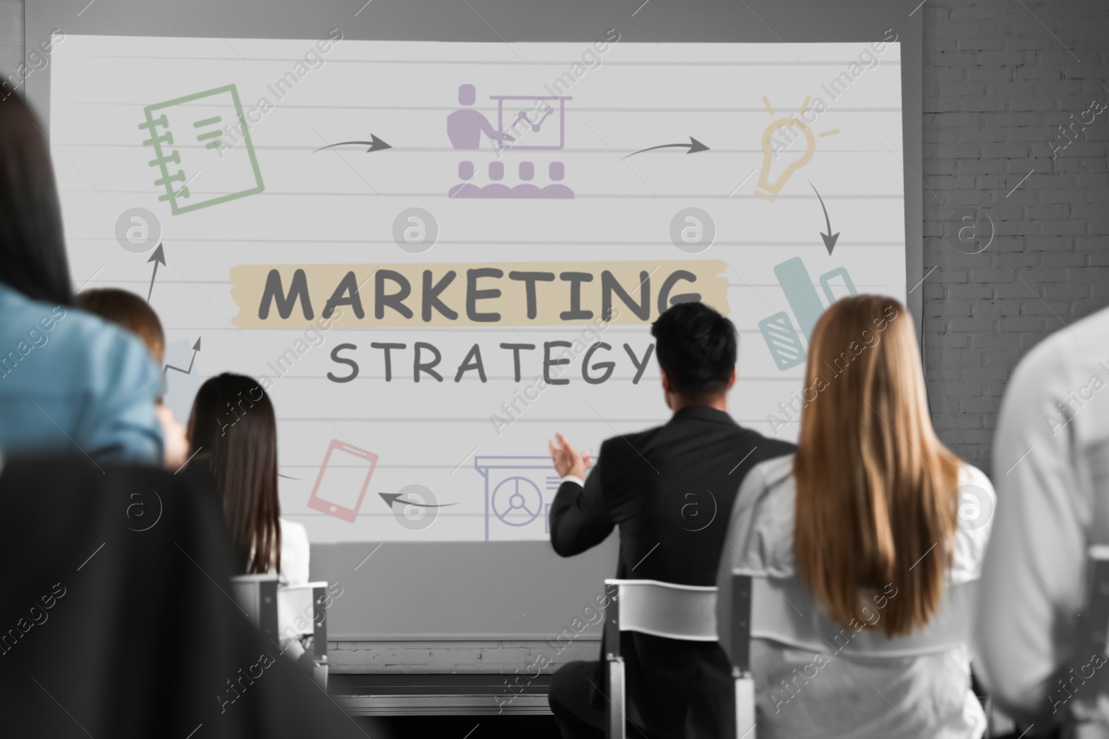 Business people having lecture using video projector in conference room. Marketing strategy scheme with illustrations on projection screen Image of Business people having lecture using video projector in conference room. Marketing strategy scheme with illustrations on projection screen