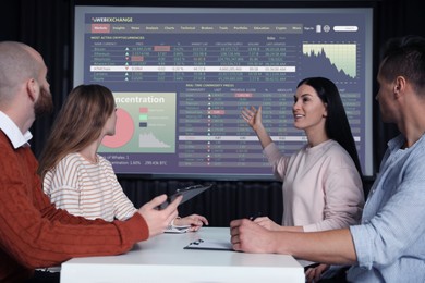 Image of Business people having conference using video projector. Graphs and data on projection screen