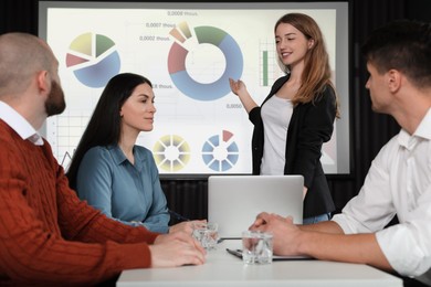 Image of Business people having conference using video projector. Graphs on projection screen