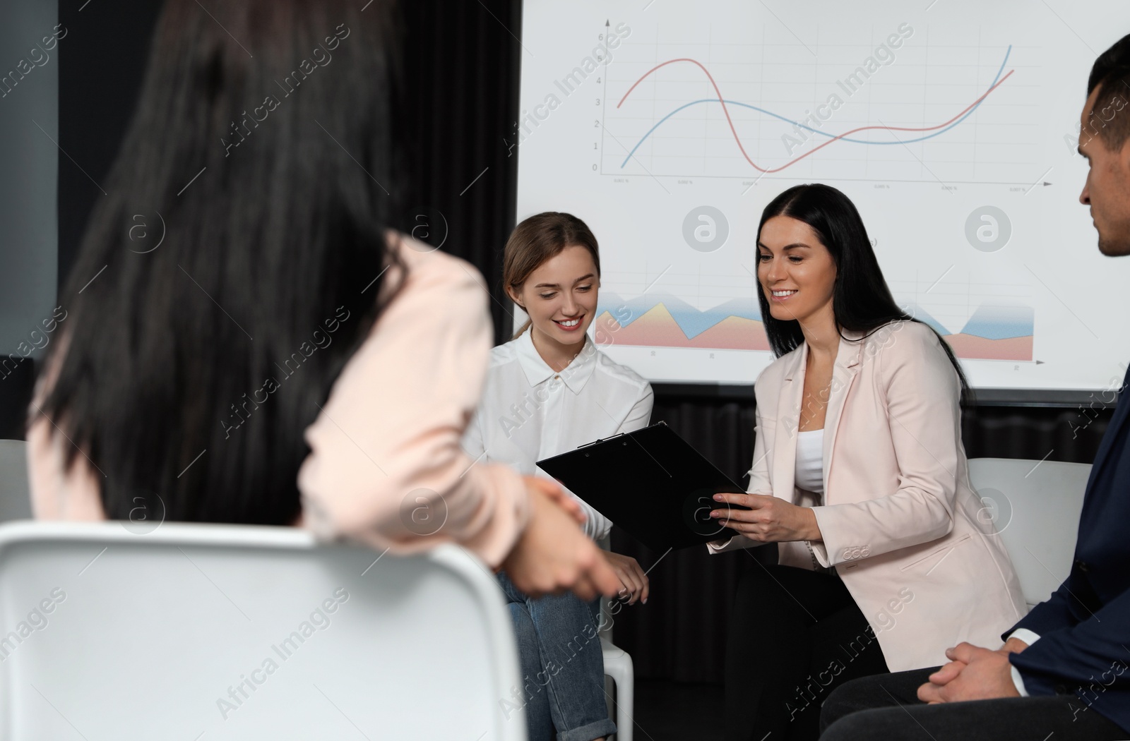 Business people having conference using video projector. Graphs on projection screen Image of Business people having conference using video projector. Graphs on projection screen