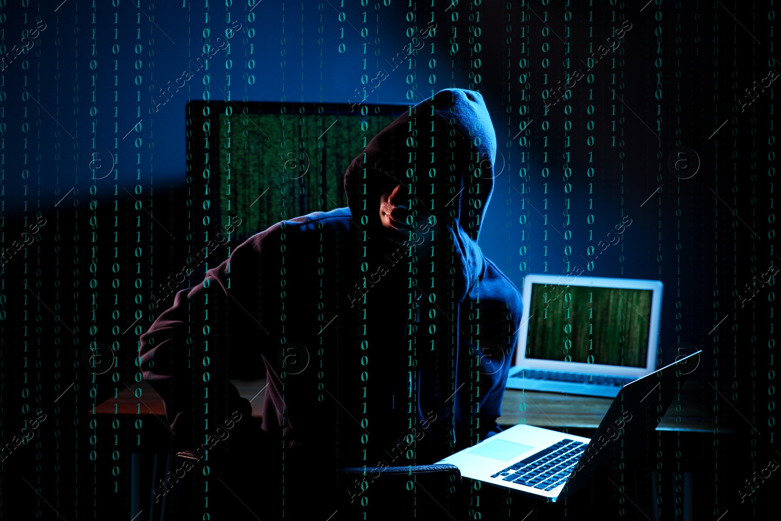 Cyber attack. Hacker working on computers in dark room. Binary code around him Image of Cyber attack. Hacker working on computers in dark room. Binary code around him