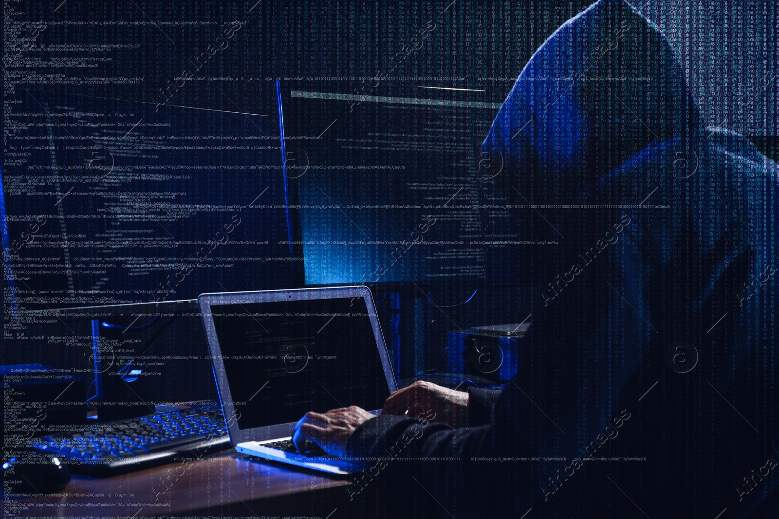Cyber attack. Hacker working on computers in dark room. Digital code around him Image of Cyber attack. Hacker working on computers in dark room. Digital code around him