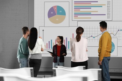 Image of People having business training using video projector in conference room. Graphs on projection screen