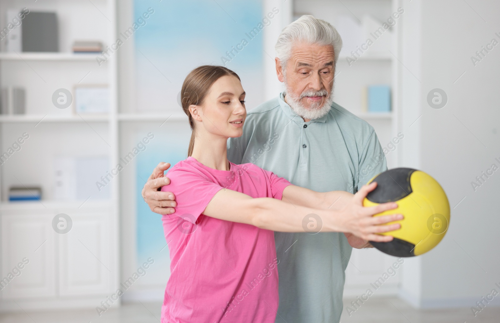 Doctor and patient exercising with medicine ball in clinic Photo of Doctor and patient exercising with medicine ball in clinic