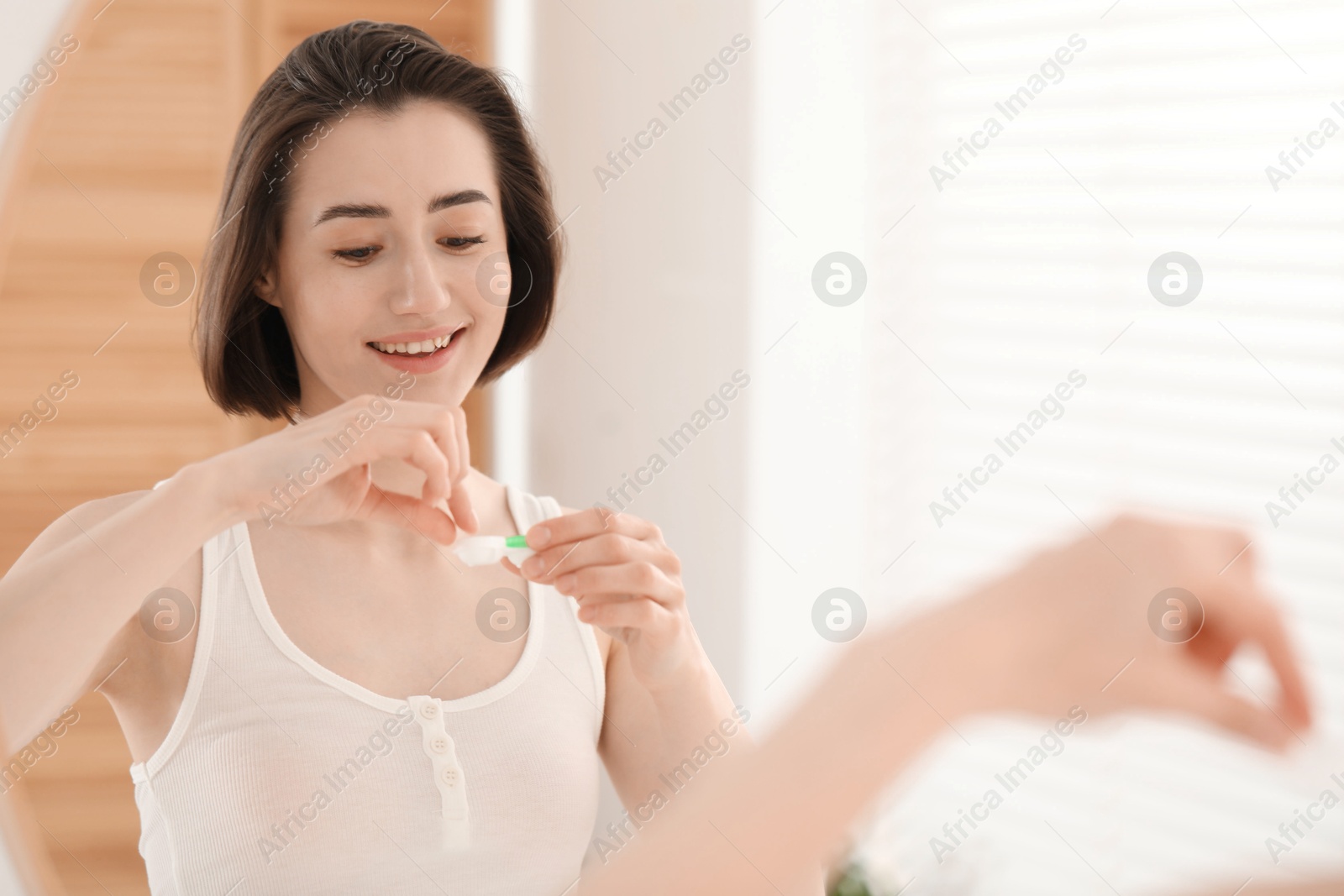 Woman taking contact lens out of case indoors. Space for text Photo of Woman taking contact lens out of case indoors. Space for text